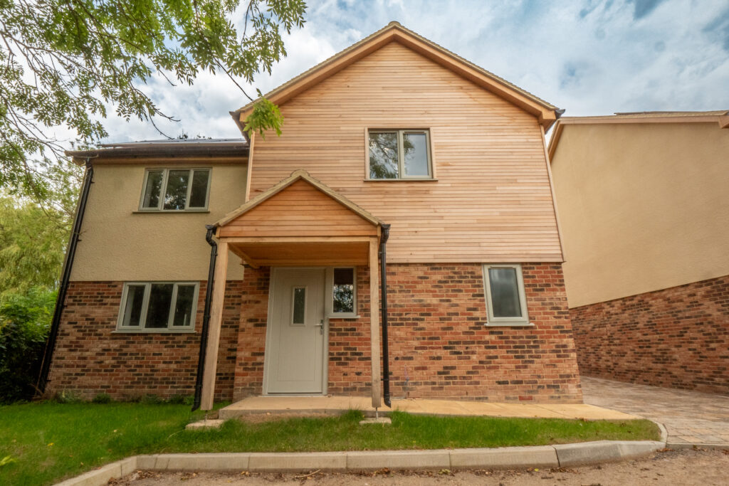 New-build detached home with timber-clad gable and finished paved access