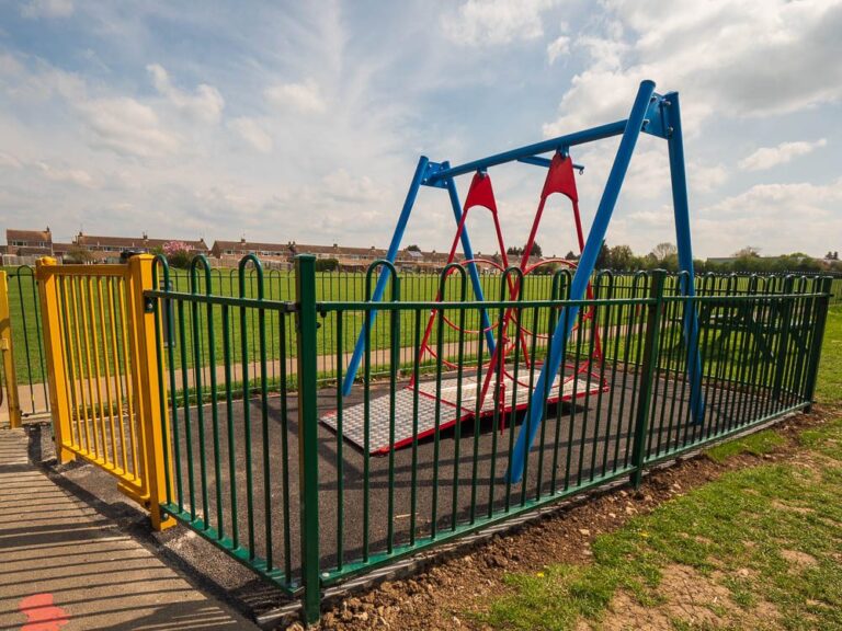Gated railing enclosure around an accessible swing.