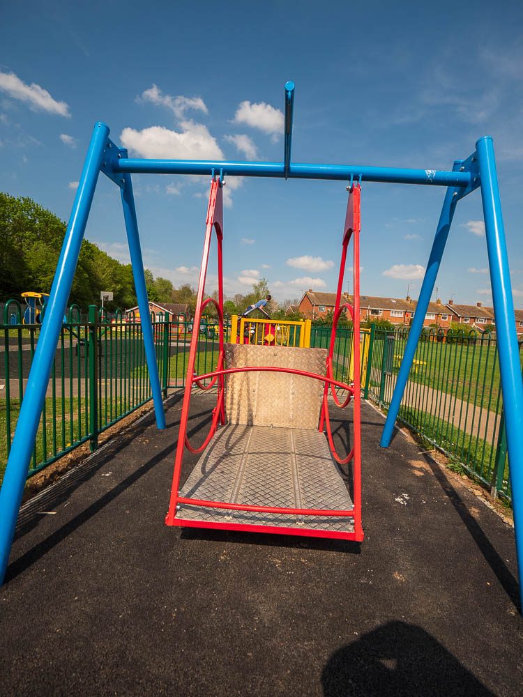 Wheelchair-accessible swing platform on new tarmac surfacing.