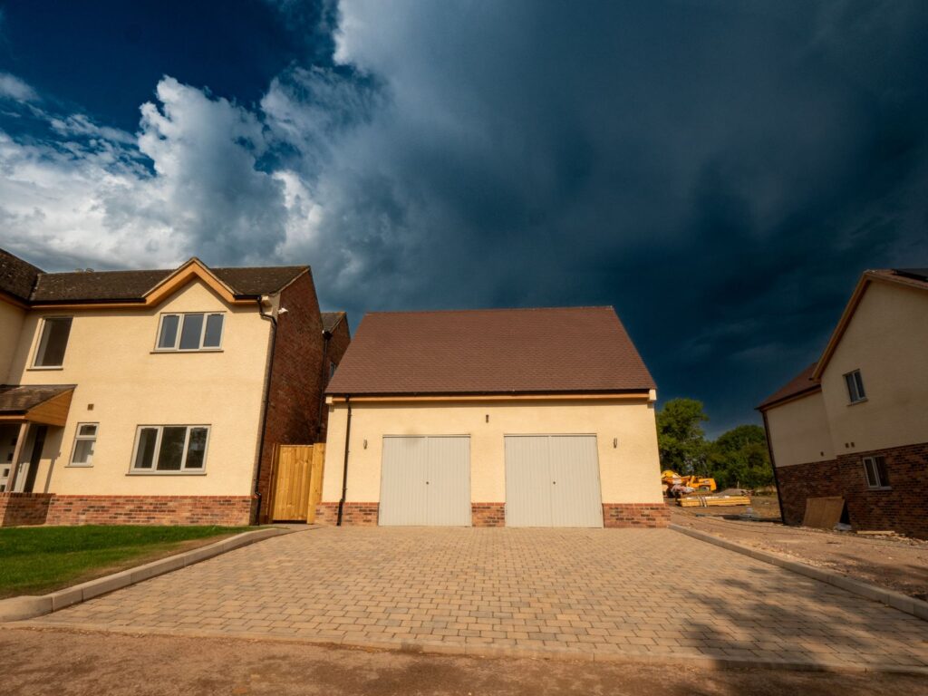 A light-grey block-paved driveway with kerb edging installed for a Gloucester double garage.