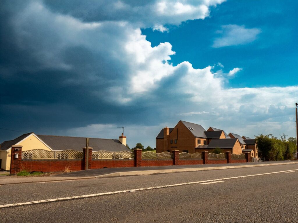 A completed brick and lattice boundary fence fronts new homes in Gloucestershire.