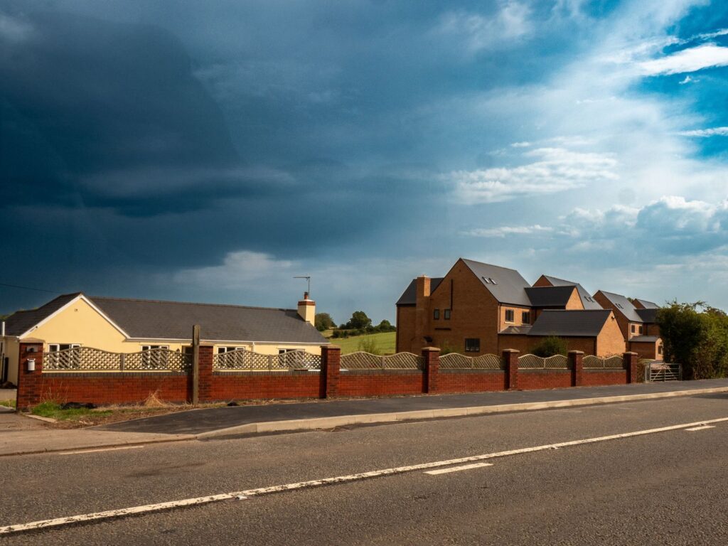 Brick pillars and decorative lattice fencing create a finished residential boundary in Gloucestershire.