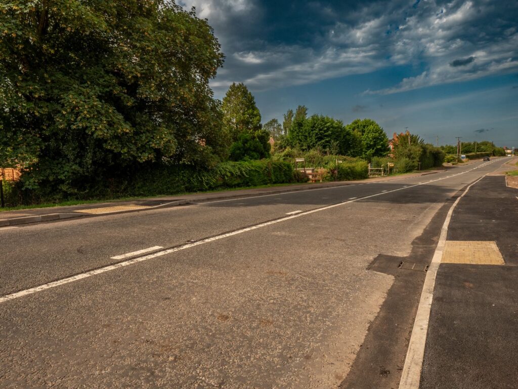 Roads and sewers improvements in Gloucestershire with a tarmac pavement, kerbs and tactile crossing panels.