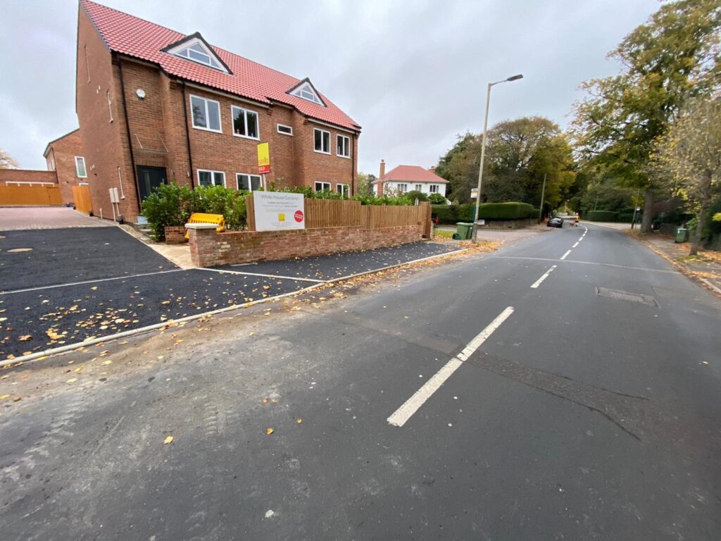 New dropped kerb and driveway access in front of new-build homes.