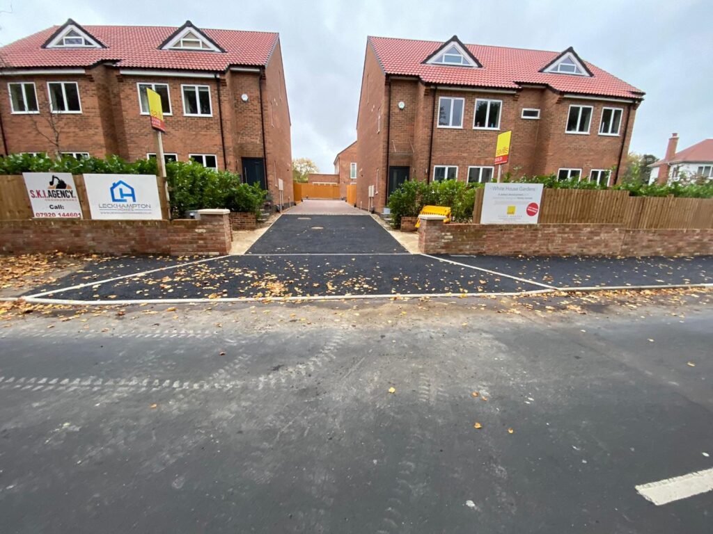 Dropped kerbs and tarmac across a new-build frontage.