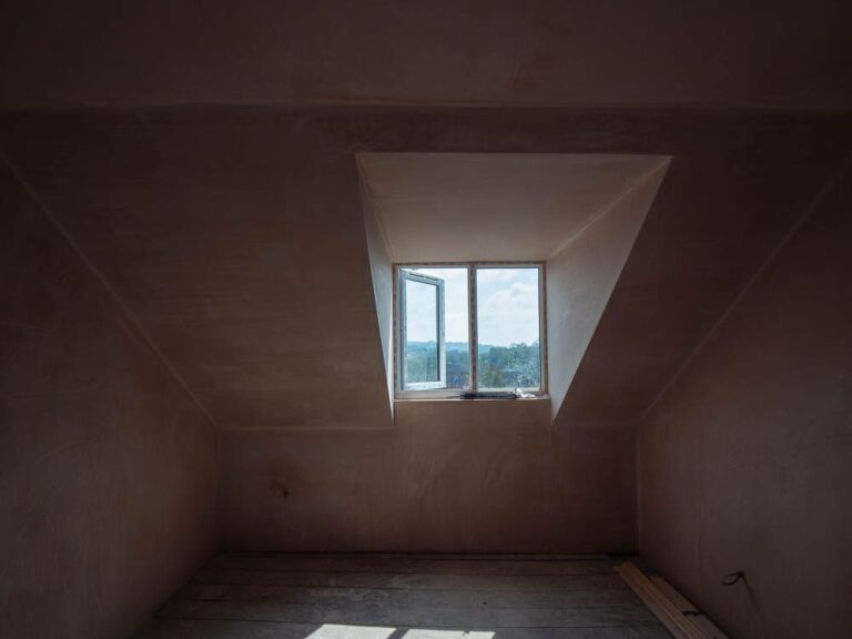 Plastered loft room with dormer window during a house renovation.