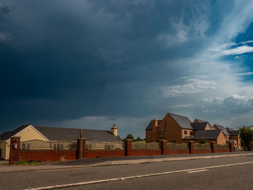 Lattice fencing on brick piers forms a finished roadside boundary for a Gloucestershire home.