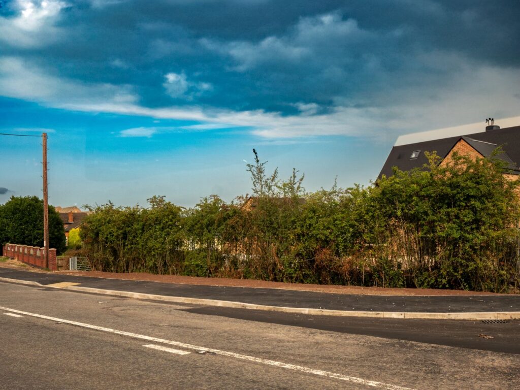 Kerbs and edgings work in Gloucestershire with a long tarmac footway, continuous kerbs and finished road edge.
