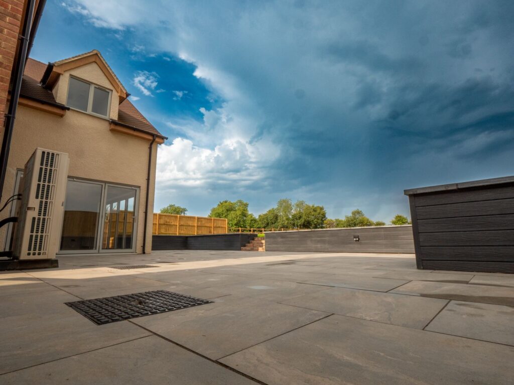 Completed grey porcelain patio with raised borders at a Gloucester property.