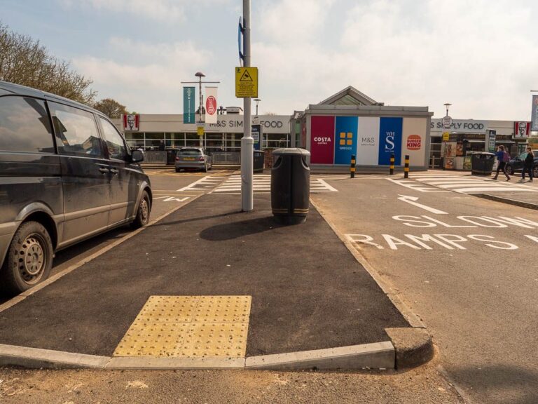 Kerbed car park island with tactile paving at Moto Leigh Delamere Services.