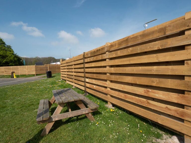 Horizontal timber slatted fencing beside a picnic area at Moto Leigh Delamere Services.
