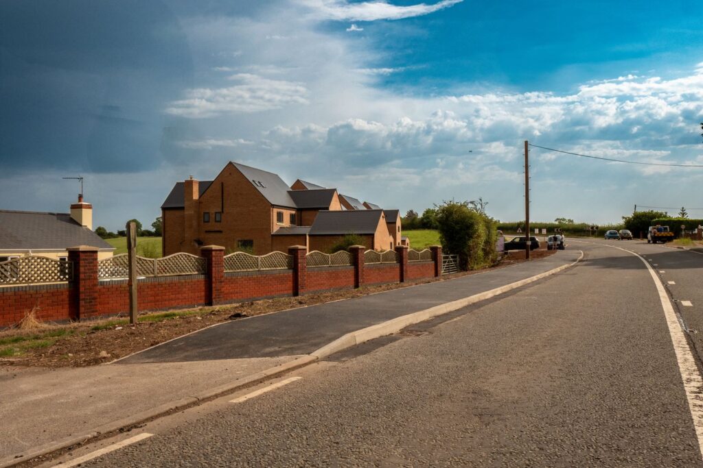 A smooth asphalt footway and new kerb show precise edging work in Gloucestershire.