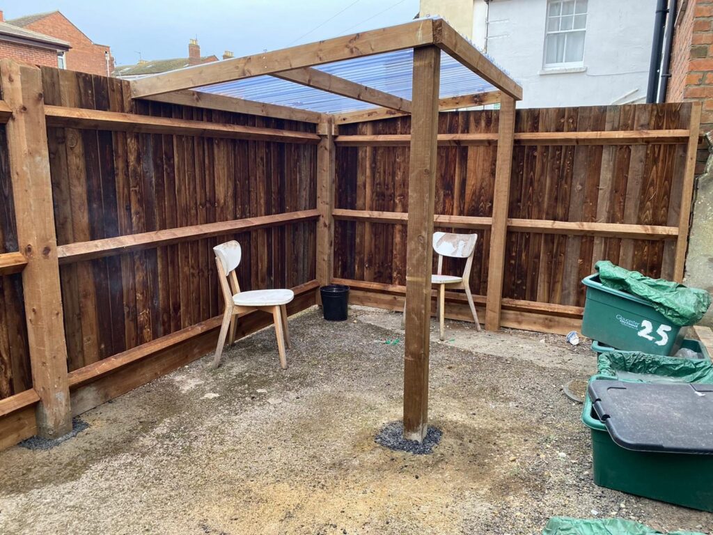 Timber fencing and pergola posts in a residential yard.